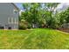 Well-maintained backyard with green lawn, a deck with umbrella, playhouse and mature trees at 3304 Buck Run Trl, Wake Forest, NC 27587