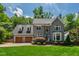 Charming gray two-story home with a manicured lawn, mature trees and an attached two-car garage at 3304 Buck Run Trl, Wake Forest, NC 27587