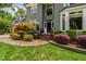 Close up of a charming gray two-story home's front entrance and landscaped front yard at 3304 Buck Run Trl, Wake Forest, NC 27587