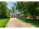 Inviting gray two-story home with an expansive driveway and lush green surroundings at 3304 Buck Run Trl, Wake Forest, NC 27587