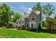 Attractive gray two-story home surrounded by lush greenery with a two-car garage on a sunny day at 3304 Buck Run Trl, Wake Forest, NC 27587