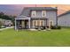 Well-maintained backyard with a screened porch, patio area, and lush green grass under colorful twilight sky at 3361 Bordwell Ridge Dr. Dr, New Hill, NC 27562