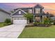 Front exterior of gray home with large driveway, lawn, and covered porch at 3361 Bordwell Ridge Dr. Dr, New Hill, NC 27562
