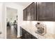 Modern kitchen area with granite countertops, dark cabinetry, and stainless steel espresso machine on counter at 3361 Bordwell Ridge Dr. Dr, New Hill, NC 27562