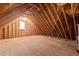 Large unfinished attic with wooden beams and a window for natural light at 3600 Trail 23 St, Durham, NC 27707