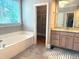 Bright bathroom featuring a jetted tub, granite vanity, and walk-in closet for ample storage space at 3600 Trail 23 St, Durham, NC 27707