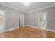 Empty bedroom with hardwood floors, chandelier, and a view into the en suite bathroom and hallway at 3600 Trail 23 St, Durham, NC 27707