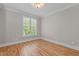 Bedroom featuring hardwood floors, crown molding, and a window view of the exterior at 3600 Trail 23 St, Durham, NC 27707