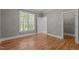 Bedroom with hardwood floors and one window with blinds at 3600 Trail 23 St, Durham, NC 27707