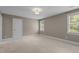 Neutral bedroom featuring carpet, a ceiling light, and two bright windows at 3600 Trail 23 St, Durham, NC 27707