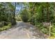 Long driveway with iron gate and lush landscaping leads to the property at 3600 Trail 23 St, Durham, NC 27707