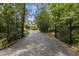 Gated entrance to a tree-lined driveway leading up to the house at 3600 Trail 23 St, Durham, NC 27707