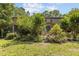 Back exterior view with lush landscaping and screened porch area, surrounded by flowering shrubs at 3600 Trail 23 St, Durham, NC 27707