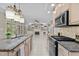 Open-concept kitchen featuring a granite island, tile floors, and modern stainless steel appliances at 3600 Trail 23 St, Durham, NC 27707