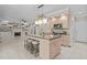 Large kitchen island with seating, pendant lighting, and views of the living area with a fireplace at 3600 Trail 23 St, Durham, NC 27707