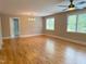 Spacious living room with gleaming hardwood floors, a ceiling fan, and bright windows at 3600 Trail 23 St, Durham, NC 27707