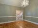 Formal dining room showcasing hardwood floors, a crystal chandelier, and staircase at 3600 Trail 23 St, Durham, NC 27707