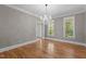 Airy living room featuring hardwood floors, a chandelier, and natural light streaming through large windows at 3600 Trail 23 St, Durham, NC 27707