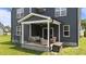 Cozy covered back porch with seating area, fan, and views of the landscaped backyard at 385 Jackson Pond Dr, Smithfield, NC 27577