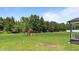 Spacious backyard featuring a large grass area, mature trees, and a playset at 385 Jackson Pond Dr, Smithfield, NC 27577