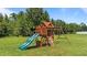 wooden playset with swings and a slide in a grass backyard at 385 Jackson Pond Dr, Smithfield, NC 27577