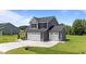 Attractive two-story home with a double garage, surrounded by green grass and a blue sky at 385 Jackson Pond Dr, Smithfield, NC 27577