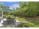 Outdoor patio area with a table and chairs, surrounded by lush greenery at 400 Indian Elm Ln, Cary, NC 27519
