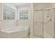 Bathroom showcasing a soaking tub and a shower with clear glass doors creating a clean, bright space at 400 Indian Elm Ln, Cary, NC 27519