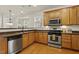 Functional kitchen featuring stainless steel appliances, wood cabinets, and a practical layout for cooking and meal preparation at 400 Indian Elm Ln, Cary, NC 27519