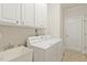 Bright laundry room features a sink, washer, dryer and ample cabinet space for storage at 400 Indian Elm Ln, Cary, NC 27519