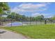 Fenced community tennis courts, surrounded by mature trees and green lawns at 400 Indian Elm Ln, Cary, NC 27519