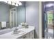 Bathroom boasts a white vanity with sink, floral accents, a large mirror, and view into the shower room at 405 Widdington Ln, Cary, NC 27519