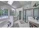 Bright bathroom with a jacuzzi bathtub, glass shower, and white cabinets at 405 Widdington Ln, Cary, NC 27519