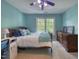 Bright bedroom with blue walls and a ceiling fan above a wooden bed near a sunny window at 405 Widdington Ln, Cary, NC 27519