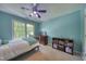 Bright bedroom with blue walls, and a wooden bed near a sunny window at 405 Widdington Ln, Cary, NC 27519