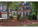 Beautiful two-story brick home featuring a bright red front door and manicured landscaping at 405 Widdington Ln, Cary, NC 27519