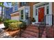 Close-up of a charming red front door with brick steps and decorative landscaping at 405 Widdington Ln, Cary, NC 27519