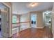 Upstairs hallway with hardwood flooring, a window, and several doorways at 405 Widdington Ln, Cary, NC 27519