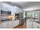 Bright kitchen boasts granite countertops, stainless steel appliances, white cabinets and an eat-in dining area at 405 Widdington Ln, Cary, NC 27519