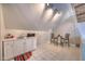 Cozy kitchenette with white cabinets, sink, microwave, and small dining area under a sloped ceiling with track lighting at 405 Widdington Ln, Cary, NC 27519
