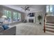 Bright living room featuring a fireplace, large windows overlooking the backyard, and a staircase to the upper level at 405 Widdington Ln, Cary, NC 27519