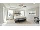 Spacious main bedroom with tray ceiling, ceiling fan, and plush carpeting features natural light from the windows at 409 Falls Bluff Dr, Wake Forest, NC 27596