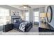 Comfortable bedroom featuring a metal frame bed, soft lighting, and three windows at 409 Falls Bluff Dr, Wake Forest, NC 27596