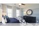 Comfortable bedroom featuring a metal frame bed, soft lighting, and three windows at 409 Falls Bluff Dr, Wake Forest, NC 27596