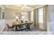 Dining room with coffered ceiling, modern chandelier, and large windows with patterned curtains at 409 Falls Bluff Dr, Wake Forest, NC 27596