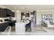 Open kitchen with gray cabinets, breakfast bar, stainless appliances, and hardwood floors at 409 Falls Bluff Dr, Wake Forest, NC 27596