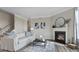 Inviting living room featuring a cozy fireplace, plush sofa, and stylish decor at 413 Falls Bluff Dr, Wake Forest, NC 27587