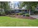 Charming blue home featuring a well-manicured lawn, mature trees and welcoming front entrance at 418 Ridgefield Rd, Chapel Hill, NC 27517