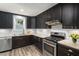 Well-lit kitchen with stainless steel appliances, subway tile backsplash, and wood-look flooring at 418 Ridgefield Rd, Chapel Hill, NC 27517