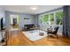 Bright living room featuring hardwood floors, stylish furnishings, and large windows with view of green space at 418 Ridgefield Rd, Chapel Hill, NC 27517